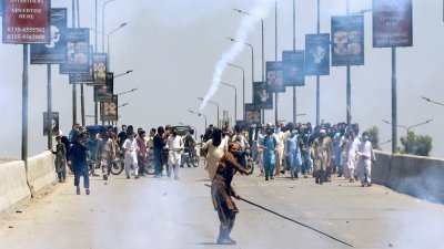 巴基斯坦前总理伊姆兰汗的支持者，周三在白沙瓦市示威时向警察投掷石块，警方则发射催泪弹驱赶示威者。（图取自路透社）
