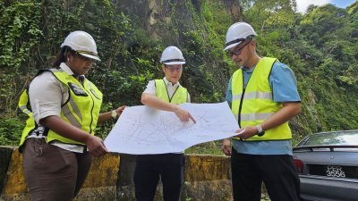 再里尔（中）向槟岛市政厅地质工程师凯特琳（左起）和哈纳菲，了解整个山壁巩固工程作业。
