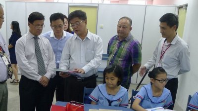 吴建成校长（左4）访问关丹中华中学时，在董事长丹斯里方天兴（左2）带领下巡视课室时，针对课程纲要交流，左为时任校长詹耀辉。