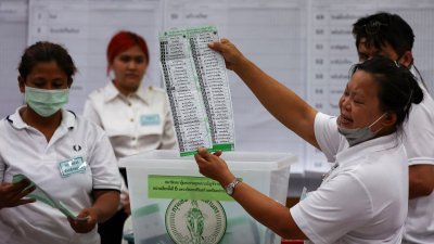 泰国周日举行国会选举，在投票时间结束后随即展开计票工作。图为工作人员在计票时的情景。（图取自路透社）