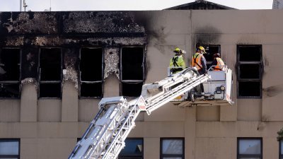 纽西兰的消防人员周三利用云梯，登上失火旅馆顶层展开调查。（图取自法新社）