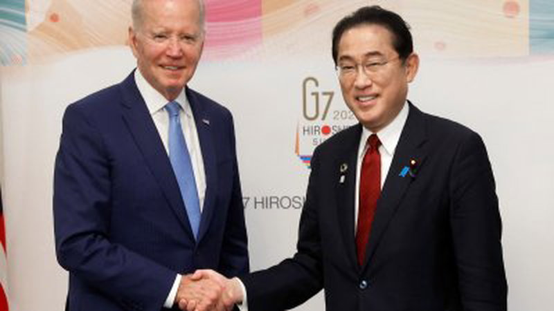 美国总统拜登（左）和日本首相岸田文雄，周四在日本广岛举行双边会晤前握手合影。（图取自路透社）