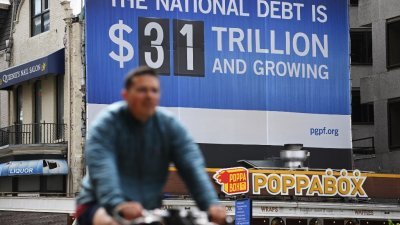 在美国华盛顿，可以看到一个显示国家债务的广告看板。（图取自法新社）
