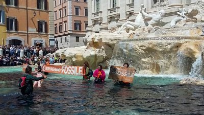 反气候变迁组织“最后一代”的7名青年当地时间周日，爬进罗马著名的特雷维喷泉中示威。他们举著“我们不会为化石（燃料）买单”的标语，将稀释的木炭汁倒入水中染黑喷泉，呼吁政府结束对化石燃料的公共补贴。（图取自法新社）