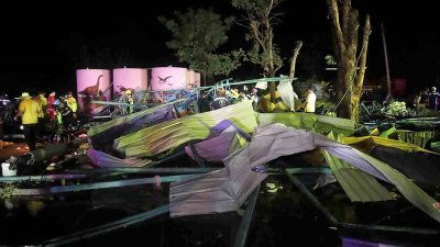 泰国披集府三昂区周一晚遭暴雨袭击，导致一所学校的体育场馆屋顶坍塌，救援人员在现场的废墟中搜寻幸存者。（图取自泰国《曼谷邮报》）