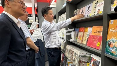 林万锋与嘉宾参观皇冠百利大众书局的“中国书架”。