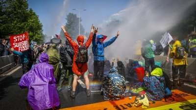 荷兰警方周六使用水柱驱离环保团体“反抗灭绝”示威人士。（图取自法新社）