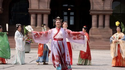 在加拿大多伦多，华人文艺团体的演员们5月21日在安大略省省议会大楼前表演汉服秀。多伦多华人团体联合总会当天在此主办以促进多元文化发展、反对种族歧视为主旨的加拿大亚裔传统月庆祝活动。（图取自中新社）