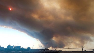 加拿大新斯科舍省哈利法克斯，当地时间周日发生野火，巨大浓烟覆盖著这个港口城市的上空。（图取自Meenakshi Guchhait/路透社）