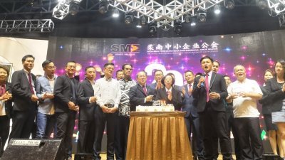 柔南中小型企业公会成立20周年，郑己胜（前排左8起）、陈瑞卿及陈天聪等带领该会理事及嘉宾主持切蛋糕仪式及唱生日歌。