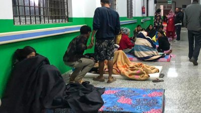 尼泊尔贾加科特地区的地震灾民到医院避难，座在医院走廊上的床垫休息。（图取自法新社）