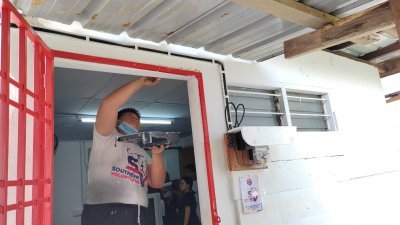 南方志工为屋子进行粉刷，让杨锦发能住的安心。