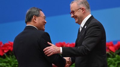 澳洲总理阿尔巴尼斯（右）周日在上海举行的中国国际进口博览会开幕式上，与中国总理李强握手。（图取自法新社）