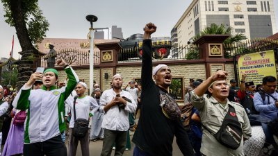 周五在印尼雅加达，示威者在警察总部前发起抗议活动，高喊口号，要求取消英国摇滚乐团酷玩乐团即将于15日举行的演唱会。（图取自法新社）