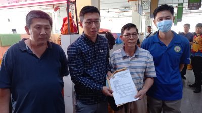 陈国勇（左二）接受了士拉央巴刹小贩公会接受了刘志南（右二）提交的备忘录，左起鸡肉摊贩、林忠智陪同见证。