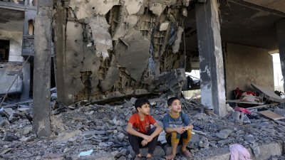 在以色列对加沙南部发动袭击之际，2名加沙儿童当地时间周五坐在建筑物的废墟中。（图取自法新社）