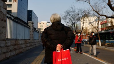 一名老人在中国北京的一家医院附近走过。（图取自路透社）