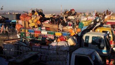在巴基斯坦的阿富汗难民，带著随身物品坐上卡车，与家人一同返回阿富汗。（图取自路透社）