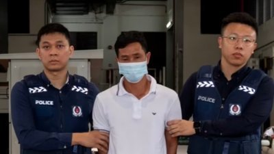 被告卢金南（译音，中）在马来西亚被捕。（图：新加坡警察部队）