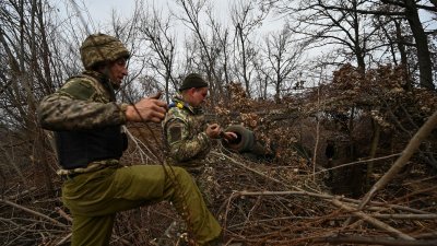 乌克兰军人在扎波罗热区前线的一处阵地，在向俄罗斯军队开火后清理2S1“格沃兹迪卡”自行榴弹炮的炮管。（图取自路透社）