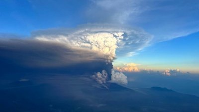 周一从飞机窗口拍摄的照片可见，巴布亚新几内亚乌拉旺火山喷发，并在高空中形成火山灰柱。（图取自路透社）