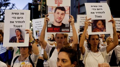 在以色列特拉维夫，抗议者周二举著人质照片和标语，要求政府与哈马斯达成协议，尽快带回人质。（图取自路透社）