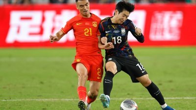 中国队球员刘彬彬（左）与韩国队球员李刚仁在比赛中拼抢。（图取自中新社）