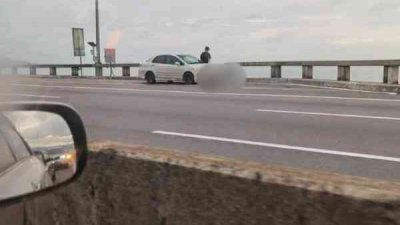 路人发现一名男子坐在槟城大桥旁企图跃下，立即通报警方求助。