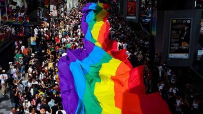 图为今年6月4日，在泰国曼谷举行的年度LGBTQ骄傲节游行，参加者举起一幅巨大的彩虹旗庆祝。（路透社档案照）