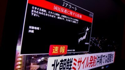 日本政府周二（21日）向日本冲绳南部县居民发出紧急警告，称朝鲜发射了一颗卫星，冲绳县居民应在室内躲避，电视屏幕上显示了标记为“J-alert”的警告信息。（图取自路透社）