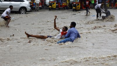 索马里首都摩加迪沙本月9日发生暴雨，一名男子试图从汹涌波涛的洪水中救人。（路透社档案照）