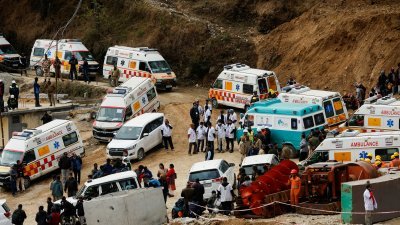 医护人员周二正在印度北阿坎德邦坍塌的一条隧道外等候，以便在41名工人被救出的第一时间将他们送往医院。（图取自路透社）