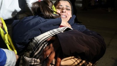 周二在约旦河西岸拉姆安拉举行的欢迎仪式上，马纳尔是最新获释的一批巴勒斯坦囚犯，她在走下红十字会巴士后，激动地抱住女儿。（图取自法新社）