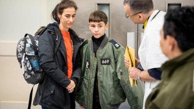 以色列总理办公室周二发布的照片显示，12岁的埃坦周一被哈马斯释放后，在母亲的陪同下在以色列特拉维夫的苏拉在斯基医疗中心进行健康检查。（图取自以色列国防军/路透社）