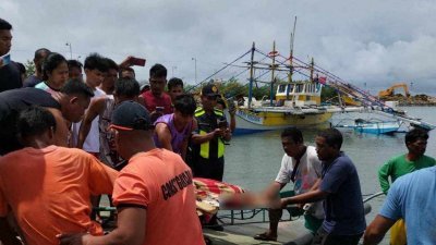一艘菲律宾渔船周一在南中国海黄岩岛附近遭外国商船撞击沉没，导致3人死亡。菲律宾海岸警卫队周三发布前一天拍摄的照片，显示一名死者的遗体被抬上岸。（图取自菲律宾海岸警卫队/路透社）
