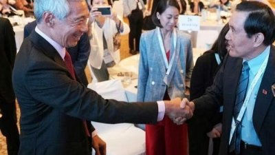 李显龙（左）与马英九在丽思卡尔顿美年酒店举行的“亚洲前瞻峰会”会场上握手打招呼。
