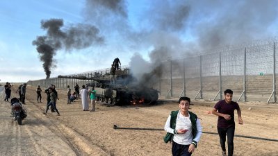 一辆以色列军车在以色列-加沙边境的以色列一侧，被渗透到以色列南部地区的巴勒斯坦枪手击中，起火燃烧。（图取自路透社）