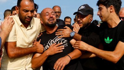 一名巴勒斯坦男性周二在加沙地带的葬礼上痛哭。（图取自路透社）