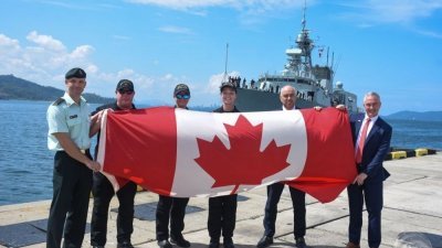 加拿大使馆人员拉起枫叶国旗迎接渥太华号。