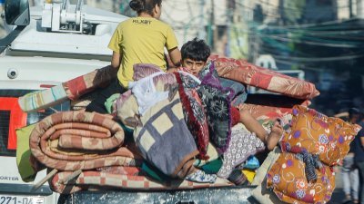 以色列和哈马斯之间的冲突持续，加沙城的巴勒斯坦人周五带上家当逃离家园。（图取自路透社）