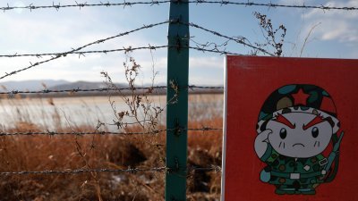 2017年11月24日，中国与朝鲜边境的铁丝网上，可见一个印著卡通士兵的警告牌子。（路透社档案照）