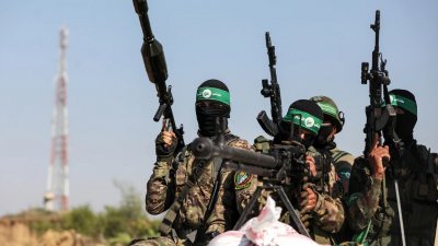 哈马斯巴勒斯坦战士在加沙地带边境的以色列军事基地附近游行。（路透社档案照）