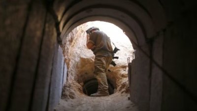一名以色列士兵在加沙地带南部郊外的艾因哈什洛沙基布兹附近观看一个被以色列军队揭露的地下隧道。（路透社档案照）