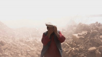 阿富汗赫拉特省津达詹地区发生严重地震，造成数十座村庄完全被毁，一名男子周二（10日）在废墟中遮住面部。（图取自路透社）