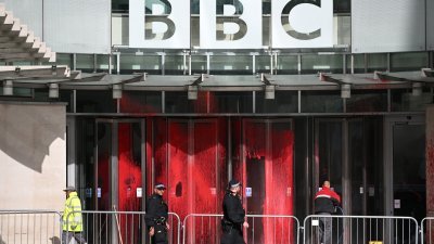 工人在清理英国广播公司（BBC）大楼入口处窗户上的红色油漆。（图取自法新社）
