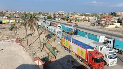 为巴勒斯坦人运送人道主义援助物资的卡车周一大排长龙，等待进入重新开放的拉法口岸，以进入加沙南部。（图取自路透社）