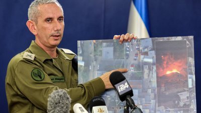 以色列的首席军事发言人哈加里少将，在周三的电视转播简报中，用卫星图讲解加沙医院周二的爆炸，是由一枚误射的巴勒斯坦火箭弹导致。（图取自法新社）