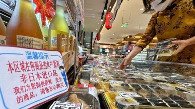 中国北京一家超市的寿司专柜，立牌说明商品的水产原料不是进口自日本。（图取自共同社/路透社）
