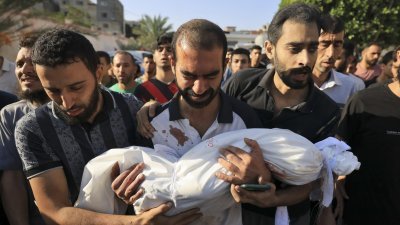 加沙地带南部当地时间周四举行的一场葬礼上，一名父亲抱著他在以色列空袭中丧生的孩子遗体痛哭。（图取自法新社）