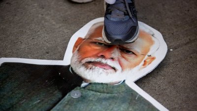 加拿大安大略省多伦多9月25日举行抗议活动，一名加拿大示威者将印有印度总理莫迪的纸板踩在脚下。（图取自路透社）